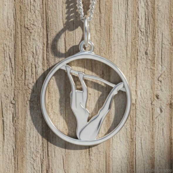 Zilveren hanger met gymnaste die een artistieke gymnastiek oefening op de brug ongelijke leggers uitvoert tijdens een wedstrijd.  
Mooi cadeau voor verjaardag.
